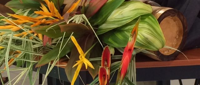 Rétroprojecteur blanc au milieu d'un bouquet de fleur tropicale.